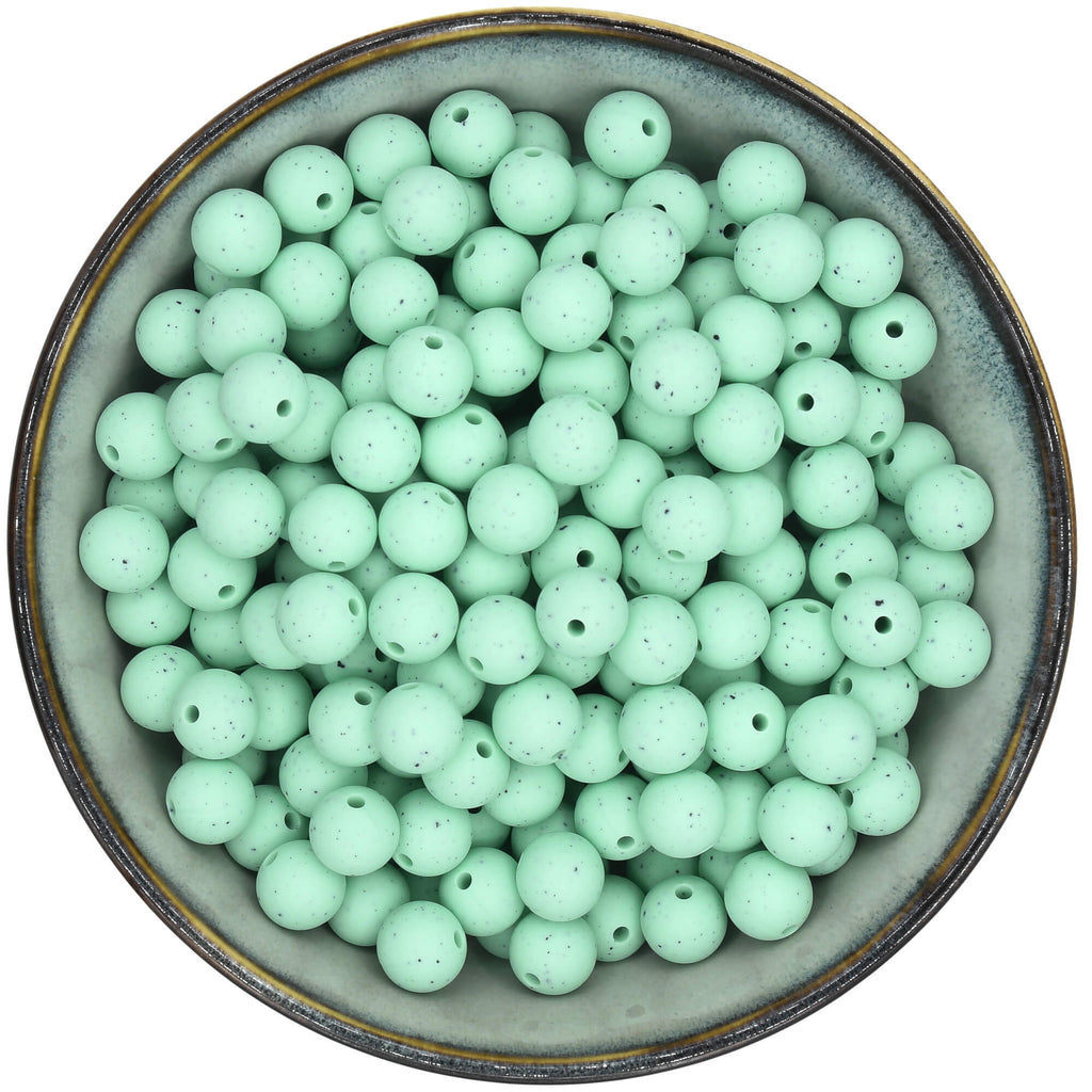 Ronde siliconen kraal van 12 mm in de kleur Mintgroen met zwarte spikkels